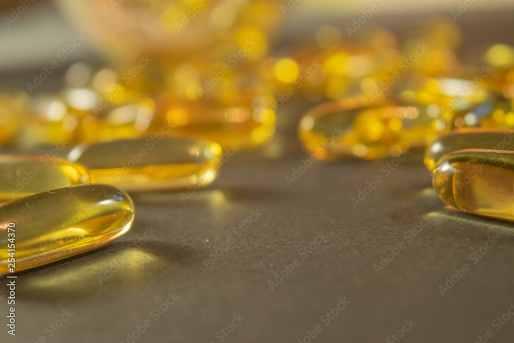 Gelatin capsules with the medicine are scattered across the table. Gelatin capsules with the medicine are scattered across the table.
