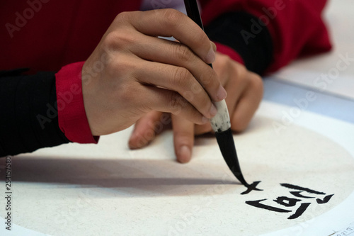 japanese woman writing ideograms with brush