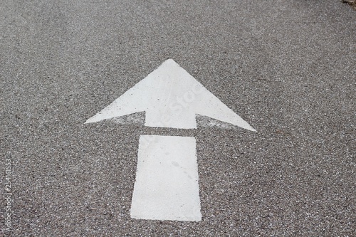 A white arrow pointing up on the concrete surface.