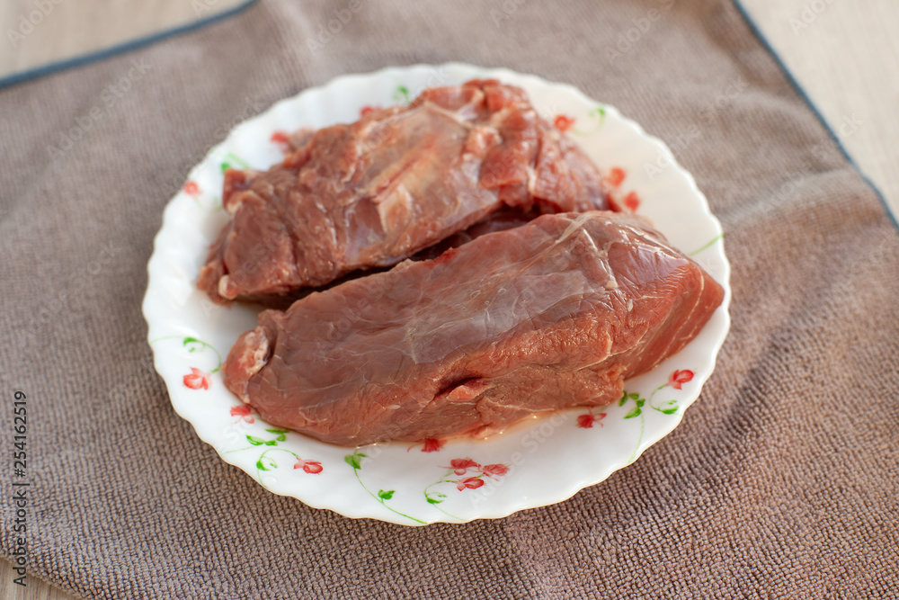 Two pieces of beef meat. Raw beef meat for cooking. Products in the kitchen and dishcloth. Ingredient in the form of beef pulp. Two pieces of beef meat. Raw beef meat for cooking. Products in the kitchen and dishcloth. Ingredient in the form of beef pulp.