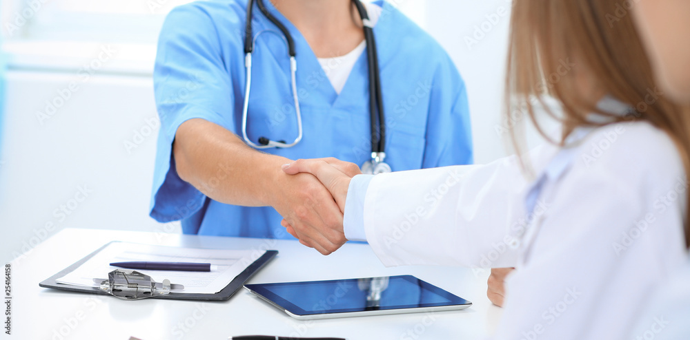 Doctors shaking hands to each other finishing up medical meeting Doctors shaking hands to each other finishing up medical meeting