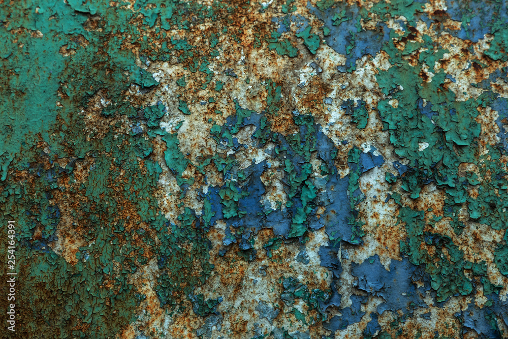 Rusty metal wall, old iron sheet, covered with rust with multi-colored paint. Trace of remnant of old paint in large deep crack on texture of surface rusty metal. Background texture old paint on metal Rusty metal wall, old iron sheet, covered with rust with multi-colored paint. Trace of remnant of old paint in large deep crack on texture of surface rusty metal. Background texture old paint on metal