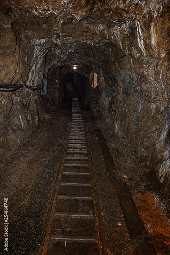 Empty old abandoned mine shaft with rusty railway