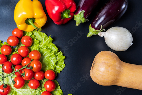 Layout with different vegetables over black background with copy space.