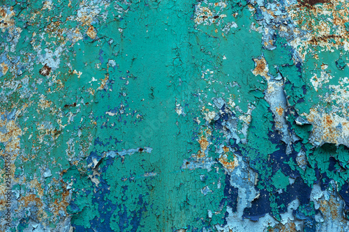 Rusty metal wall  old iron sheet  covered with rust with multi-colored paint. Trace of remnant of old paint in large deep crack on texture of surface rusty metal. Background texture old paint on metal