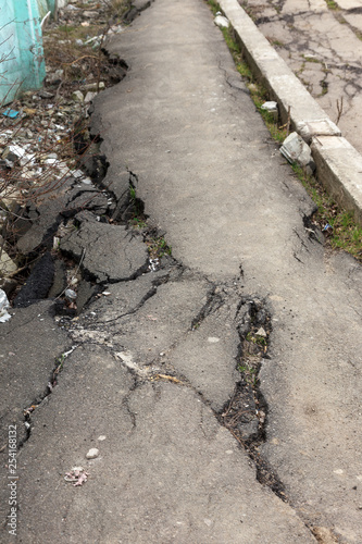 Landslide caused by rains of hurricane destroyed expensive cottages and houses. Destroyed house, cottage, large cracks, chips, slabs. Broken asphalt shifted landslide after earthquake. View from drone