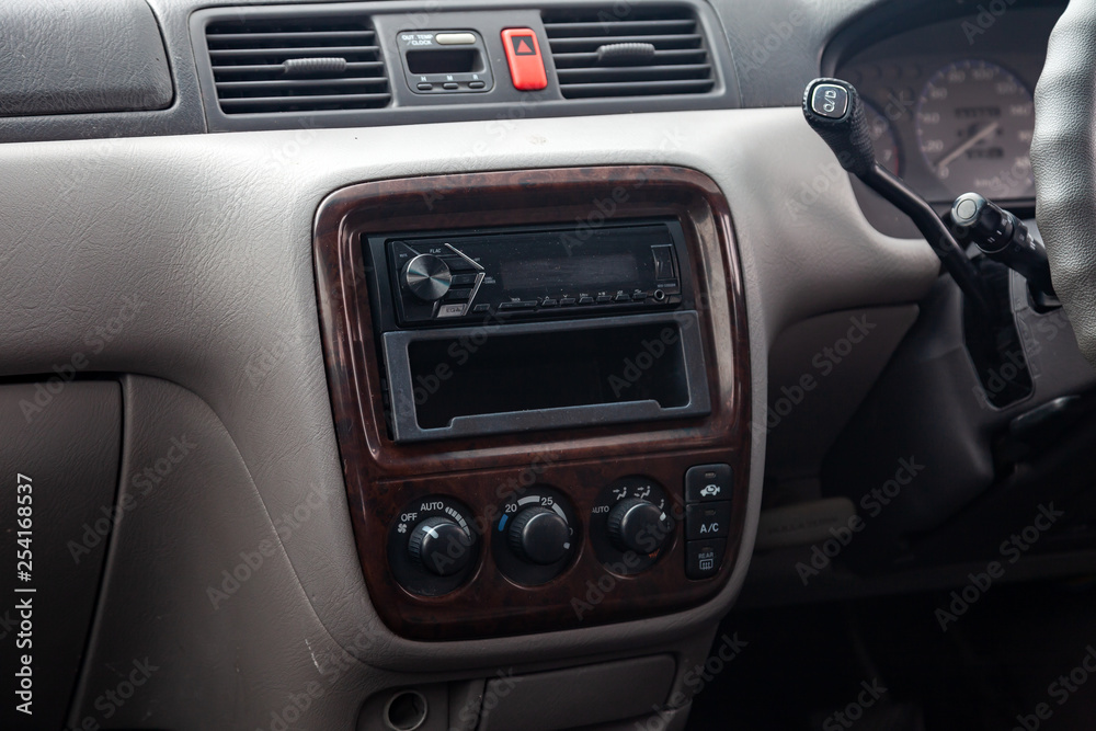 Close-up on climate control buttons and audio system in the interior of an old Japanese car in gray after dry cleaning