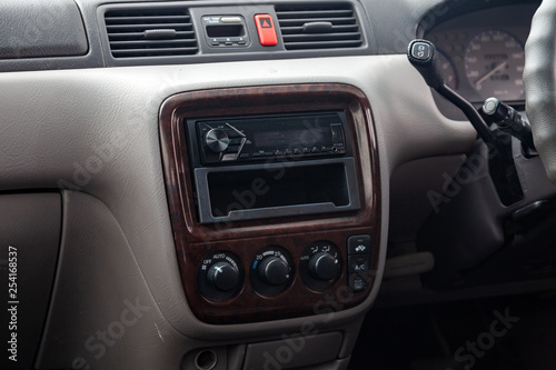 Close-up on climate control buttons and audio system in the interior of an old Japanese car in gray after dry cleaning © Aleksandr Kondratov