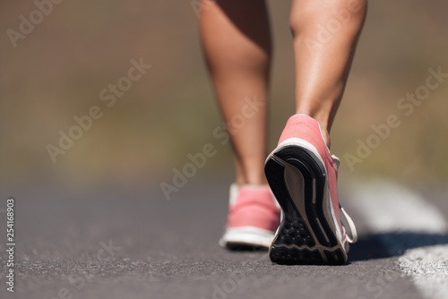 Running shoe closeup of woman running on road with sports shoes