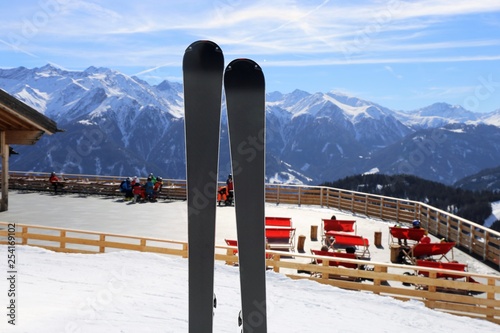 Ski im Schnee und Liegestühle im Hintergrund