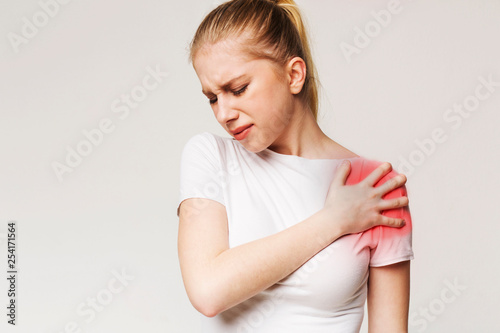 Tablou pe pânză Young woman suffering from pain in shoulder