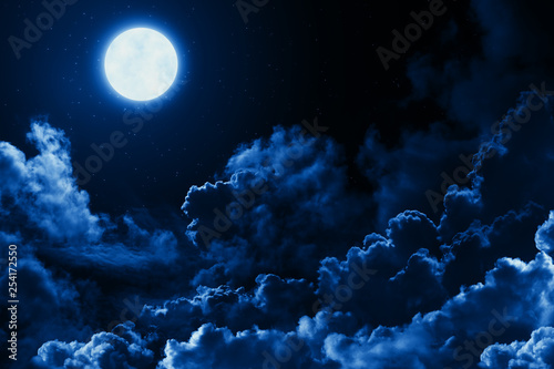 Mystical bright full moon in the midnight sky with stars surrounded by dramatic clouds. Dark natural background with twilight night sky with moon and clouds