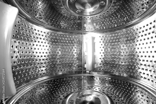 A look inside the perforated steel drum of the empty washing machine. 