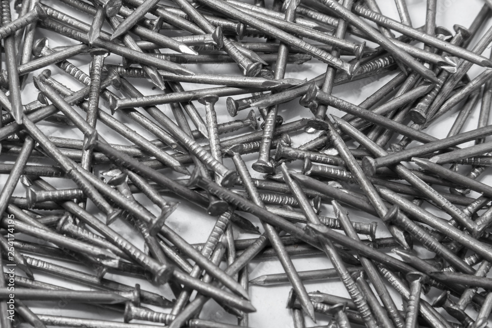The pile of metal nails lies on the white background. The pile of metal nails lies on the white background.