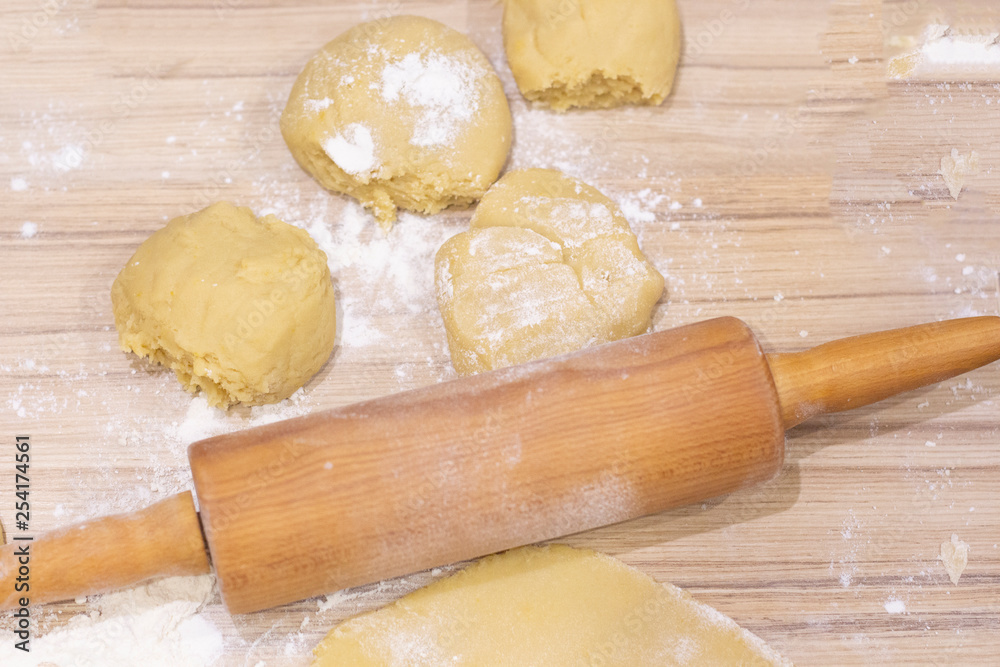 background. a wooden rolling pin with the test lie on a table background. a wooden rolling pin with the test lie on a table