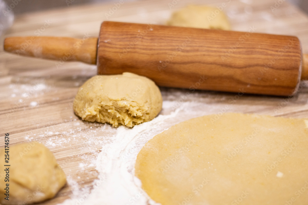 background. a wooden rolling pin with the test lie on a table background. a wooden rolling pin with the test lie on a table