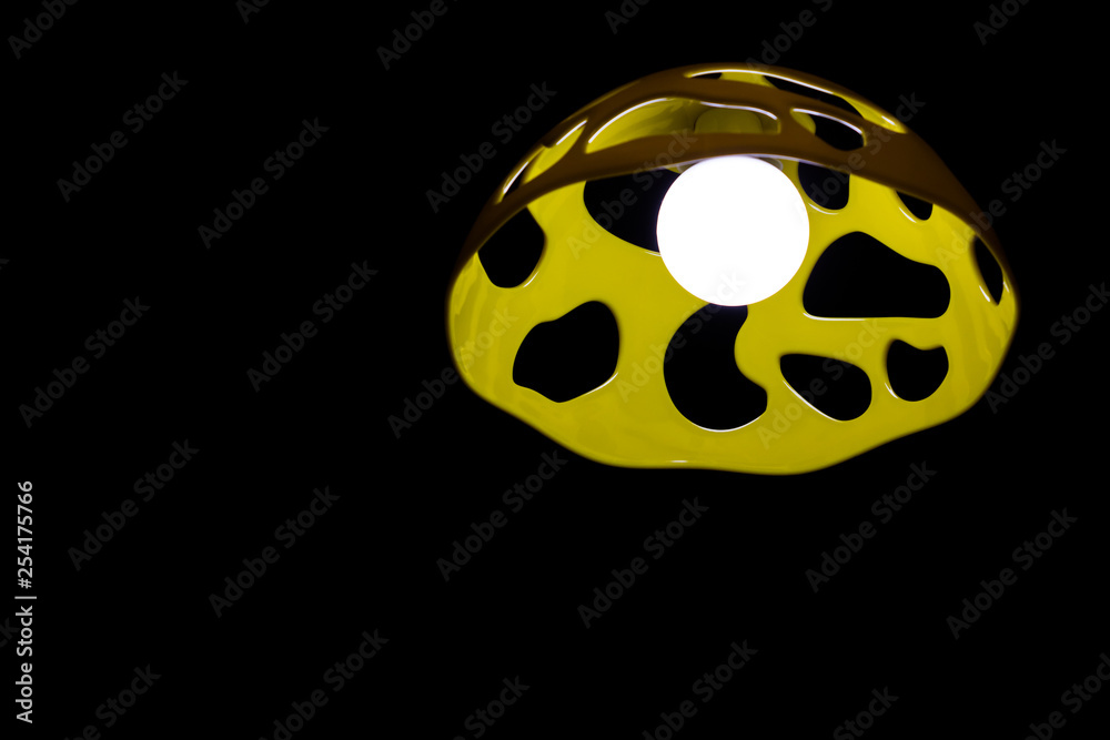 Lamp with yellow shade on the black background Lamp with yellow shade on the black background