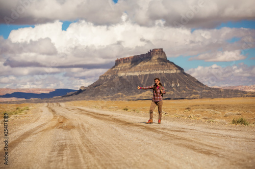 hitchhiker woman walking on a road in USA