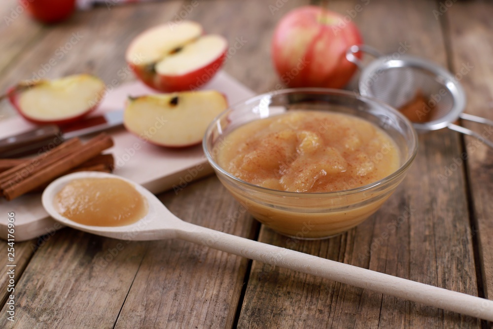 homemade apple jam, with fresh apples and spices with wooden spoon on wooden rustic table homemade apple jam, with fresh apples and spices with wooden spoon on wooden rustic table