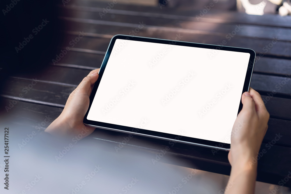 Woman holding tablet mock up of blank screen on the table. Woman holding tablet mock up of blank screen on the table.