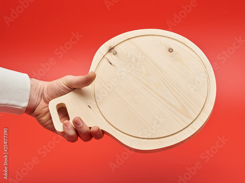 handmade cutting board, unusual shape, made of wood on a red background