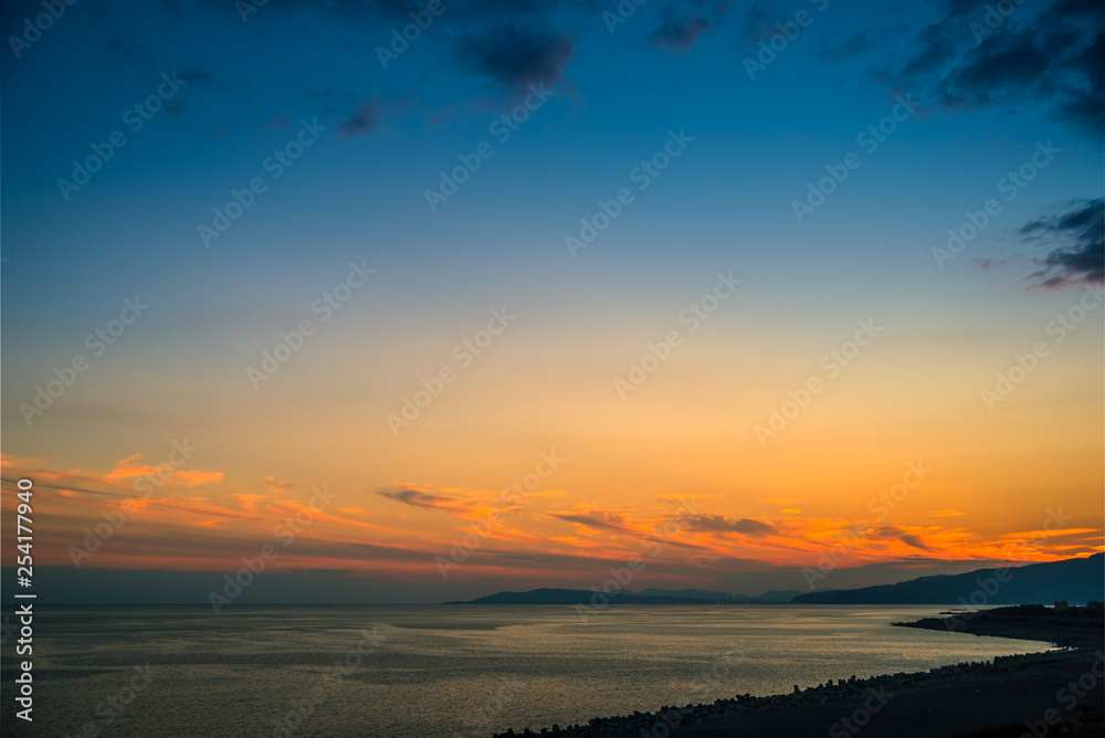 Colorful sunset with dramatic sky background over sea.