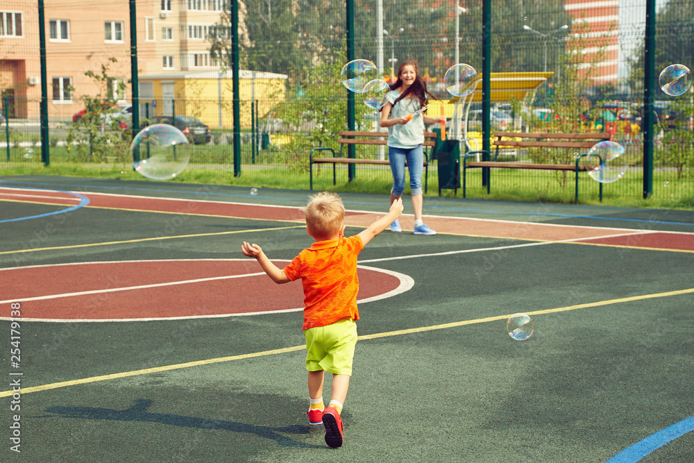 Fototapeta premium child with mother playing with bubble blower