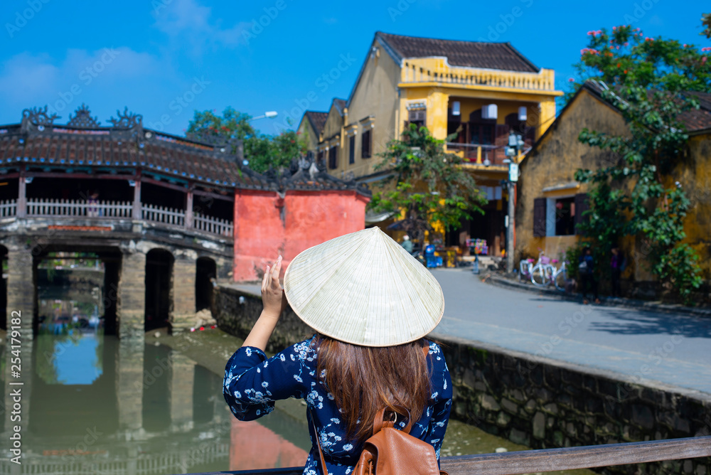 Woman tourist is travel into old town village in Hoi An, Vietnam.