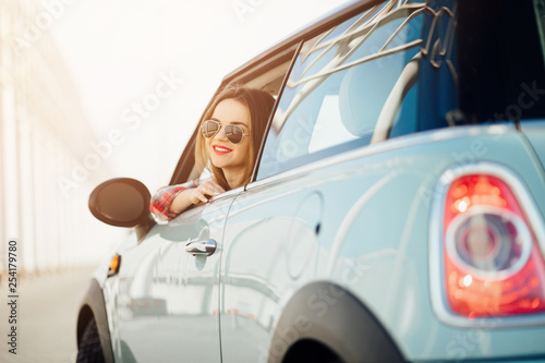 Happy young woman driving her sports car. Traveling concept.