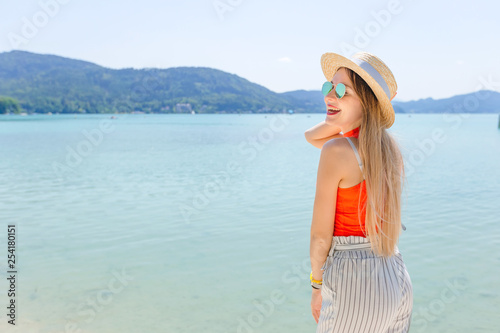 girl in summer clothes and sunglasses smile near the lake. mount