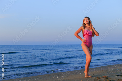 beautiful girl with long hair in a pink swimsuit closed her eyes