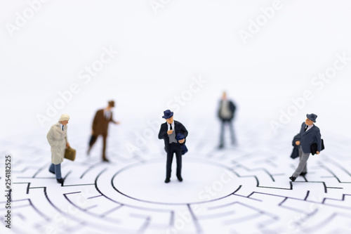 Miniature people : Businessmen standing on maze map and looking for a solution with teamwork. Image use for solve problems and new idea concept.