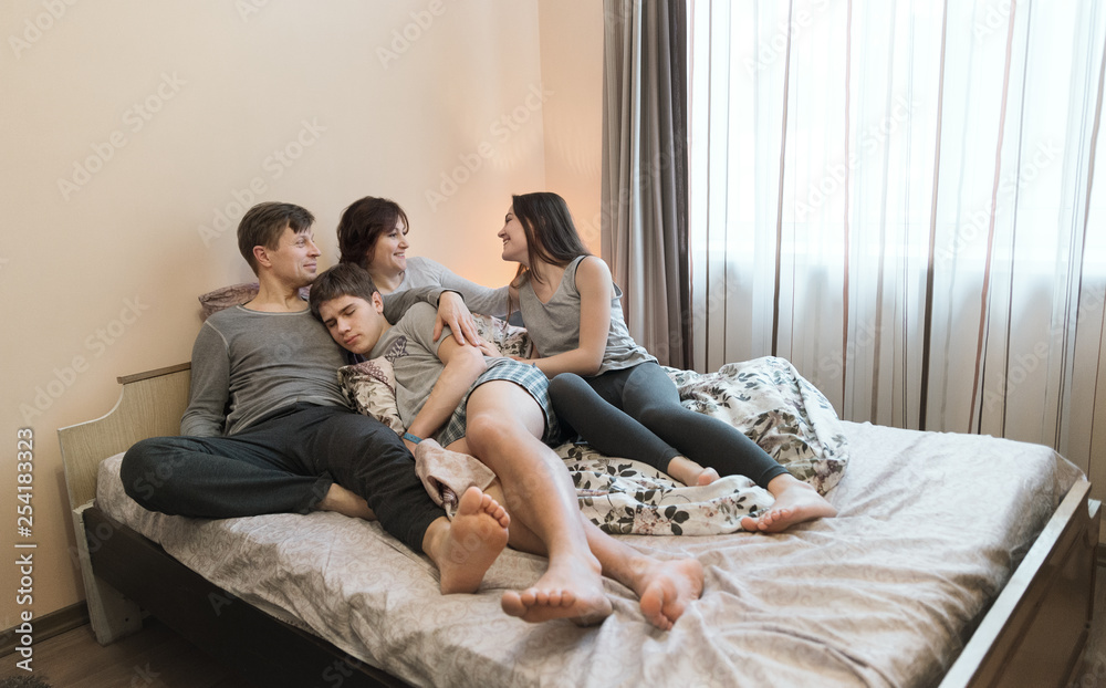 Happy parents and сhildren enjoying their morning in bed Happy parents and сhildren enjoying their morning in bed