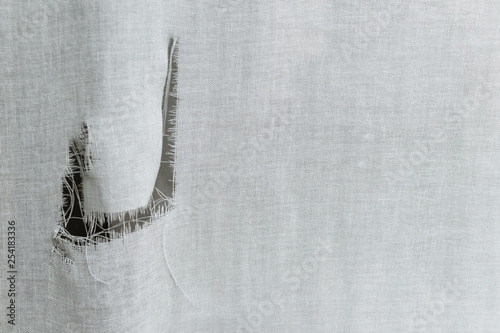 hole on an aged by sun  fabric background