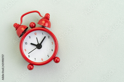 Flat lay of red alarm clock on texture white background with copy space using as time, deadline or schedule presentation wallpaper
