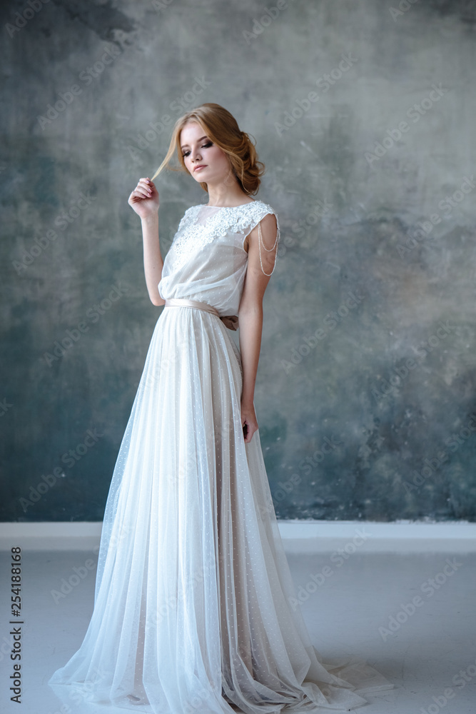 Bride blonde woman in a modern color wedding dress with elegant hair style and make up. Fashion beauty portrait over textured background Bride blonde woman in a modern color wedding dress with elegant hair style and make up. Fashion beauty portrait over textured background