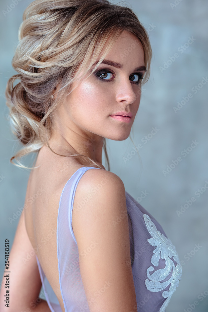 Bride blonde woman in a modern color wedding dress with elegant hair style and make up. Fashion beauty portrait over textured background Bride blonde woman in a modern color wedding dress with elegant hair style and make up. Fashion beauty portrait over textured background