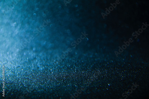 Bokeh defocused glittering lights blurred abstract blue black dark background