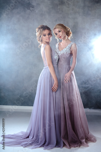 Bride blonde young women in a modern color wedding dress with elegant hair style and make up. Fashion beauty portrait composition over textured background