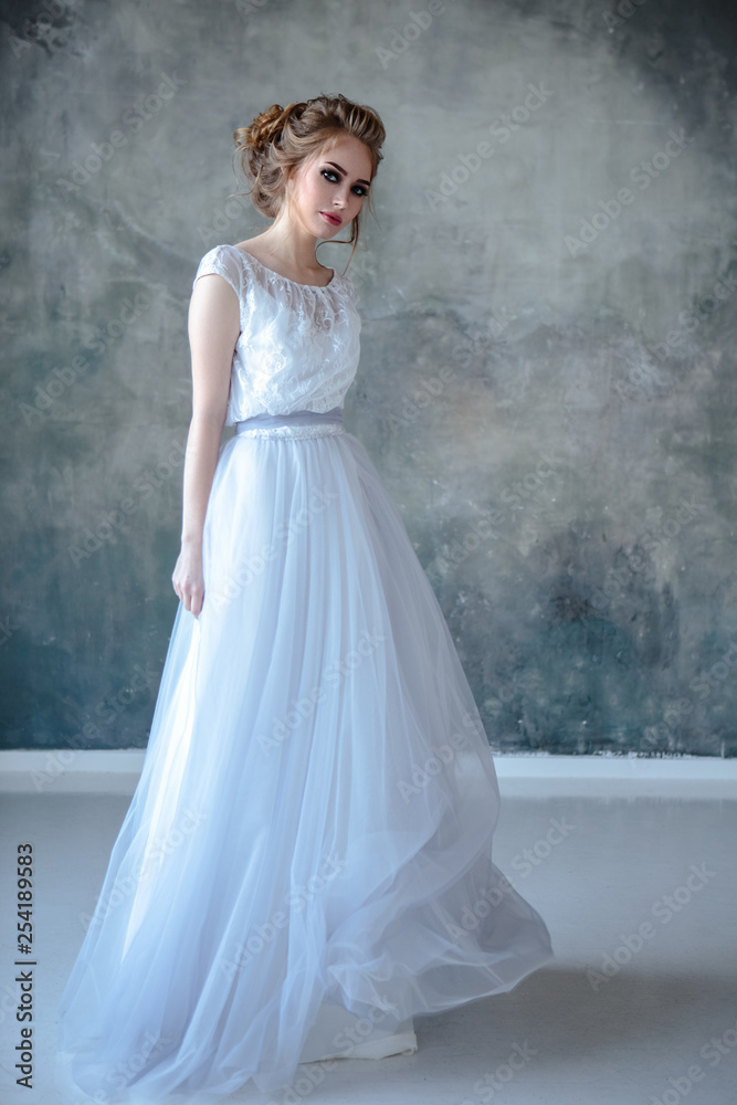 Bride blonde woman in a modern color wedding dress with elegant hair style and make up. Fashion beauty portrait over textured background Bride blonde woman in a modern color wedding dress with elegant hair style and make up. Fashion beauty portrait over textured background