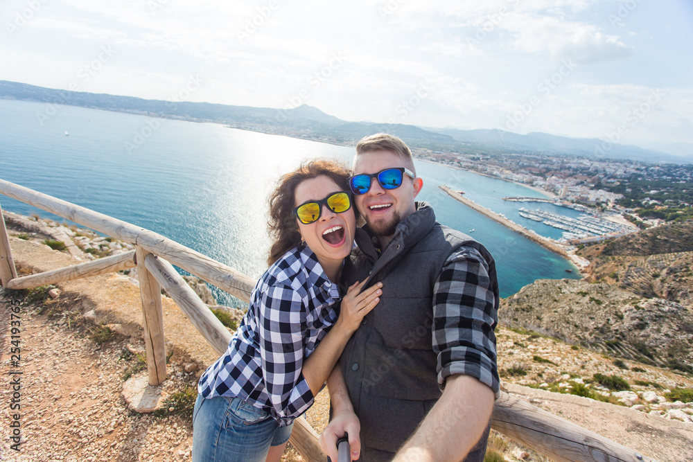 Travel, vacation and holiday concept - Nice couple taking selfie near a sea