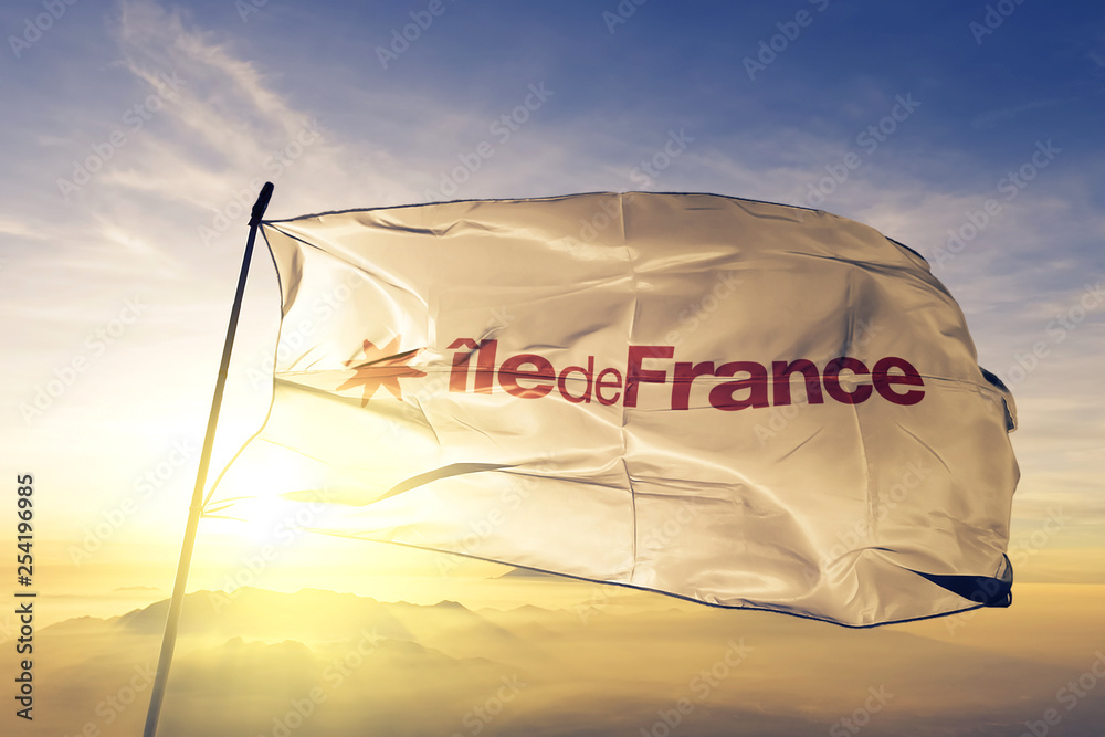Ile-de-France of France flag waving on the top sunrise mist fog