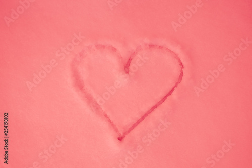 Pink heart painted on pink snow  close-up