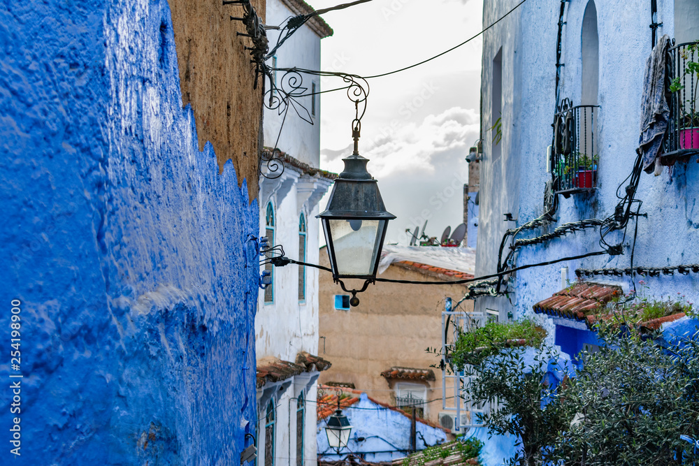 Hanging Streetlight in a Narrow Street in Chefchaouen Morocco with Blue Buildings