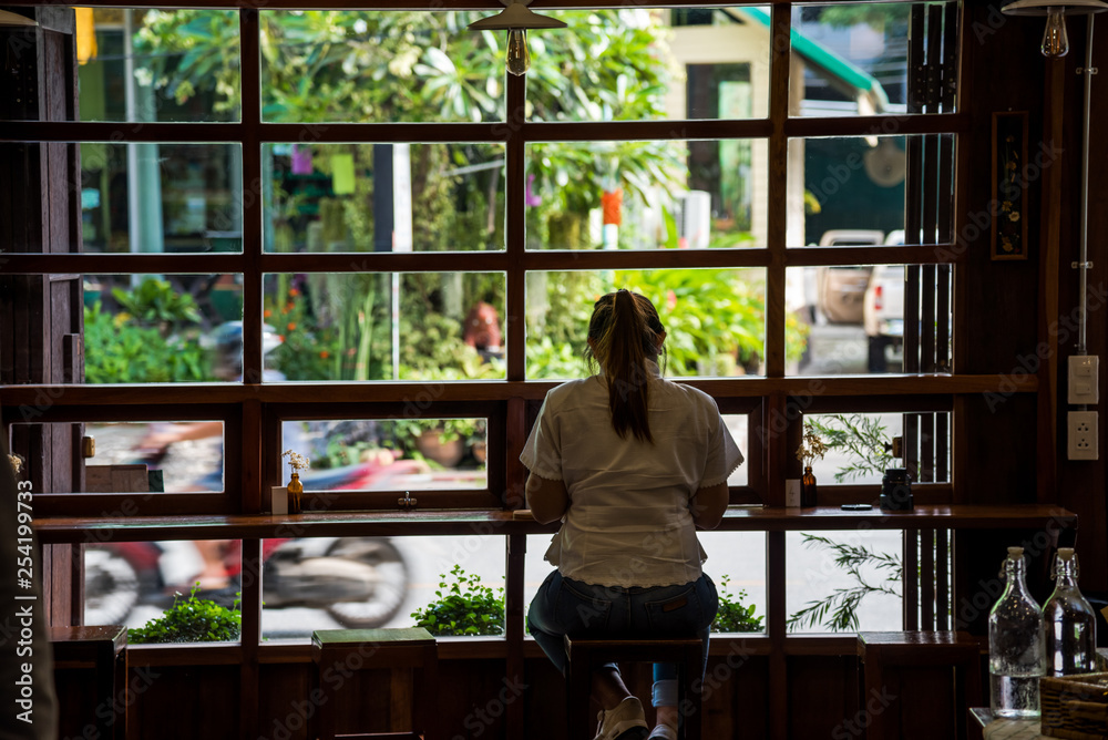 A woman sitting at the bar alone enjoy her dessert in cafe. A woman sitting at the bar alone enjoy her dessert in cafe.