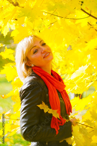 young beautiful blonde girl in yellow foliage, smiling on a walk in the fores