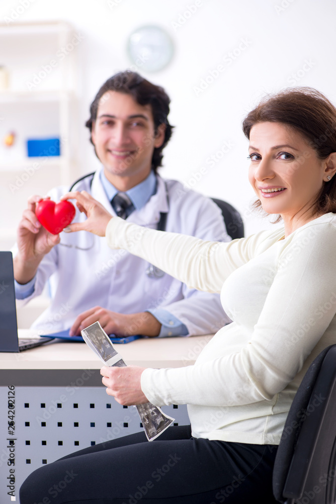Fototapeta premium Old pregnant woman visiting young male doctor 