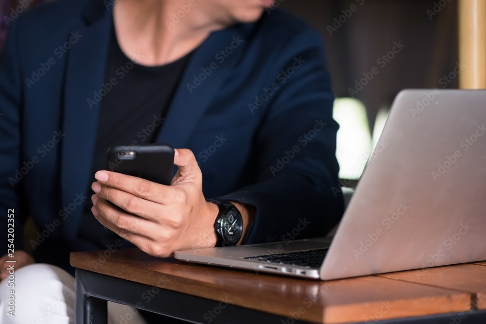 Asian business man working with his smartphone in coffee shop in selective focus. Asian business man working with his smartphone in coffee shop in selective focus.