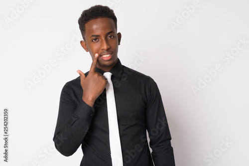 Portrait of happy young African businessman touching face