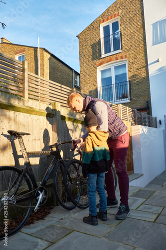 Dad and son are repairing the wheel on the bike, getting ready for a walk